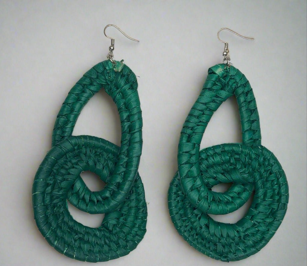 Pair of green knotted earrings on a white dish