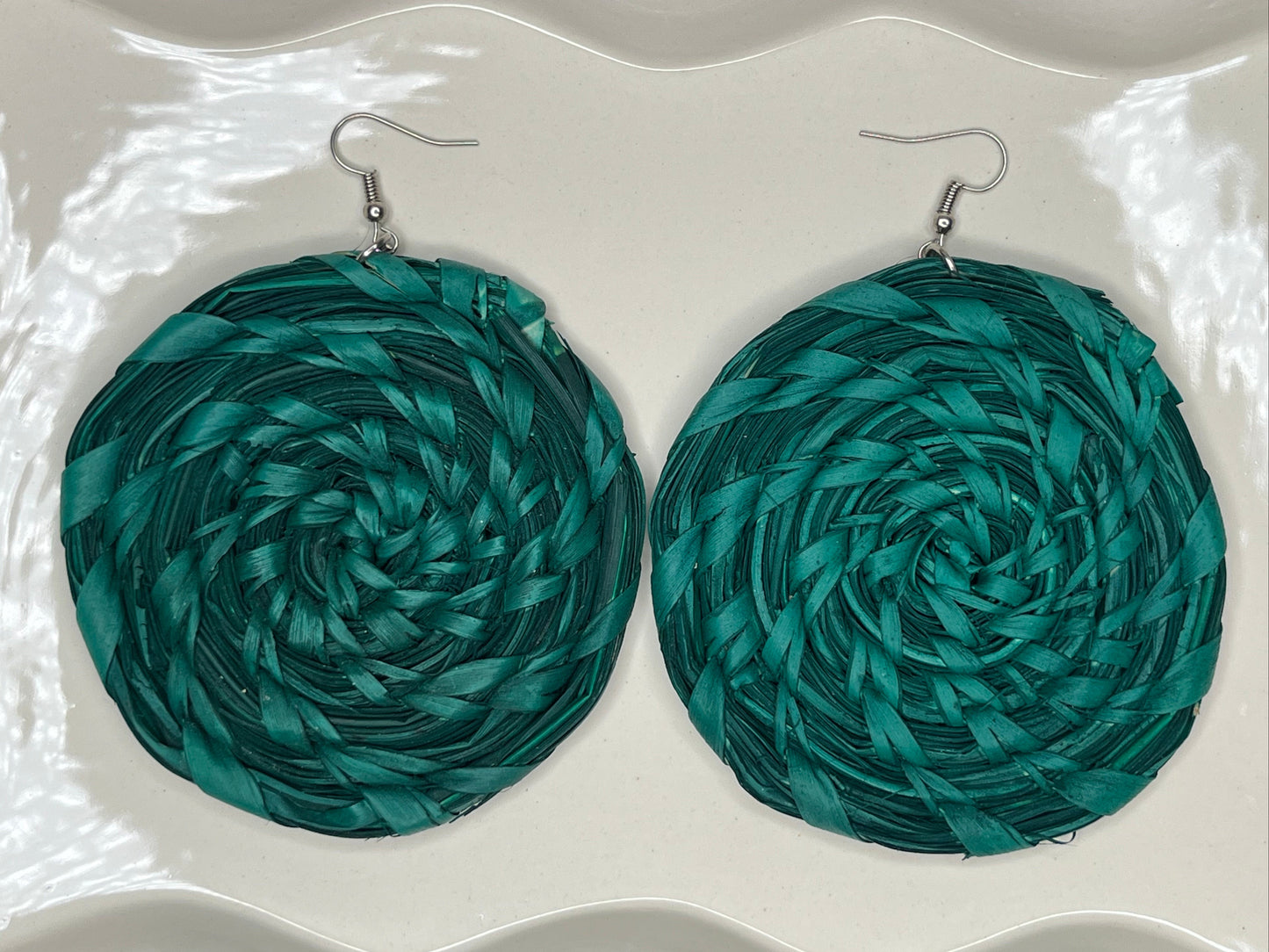 Teal circular earrings on a white tray