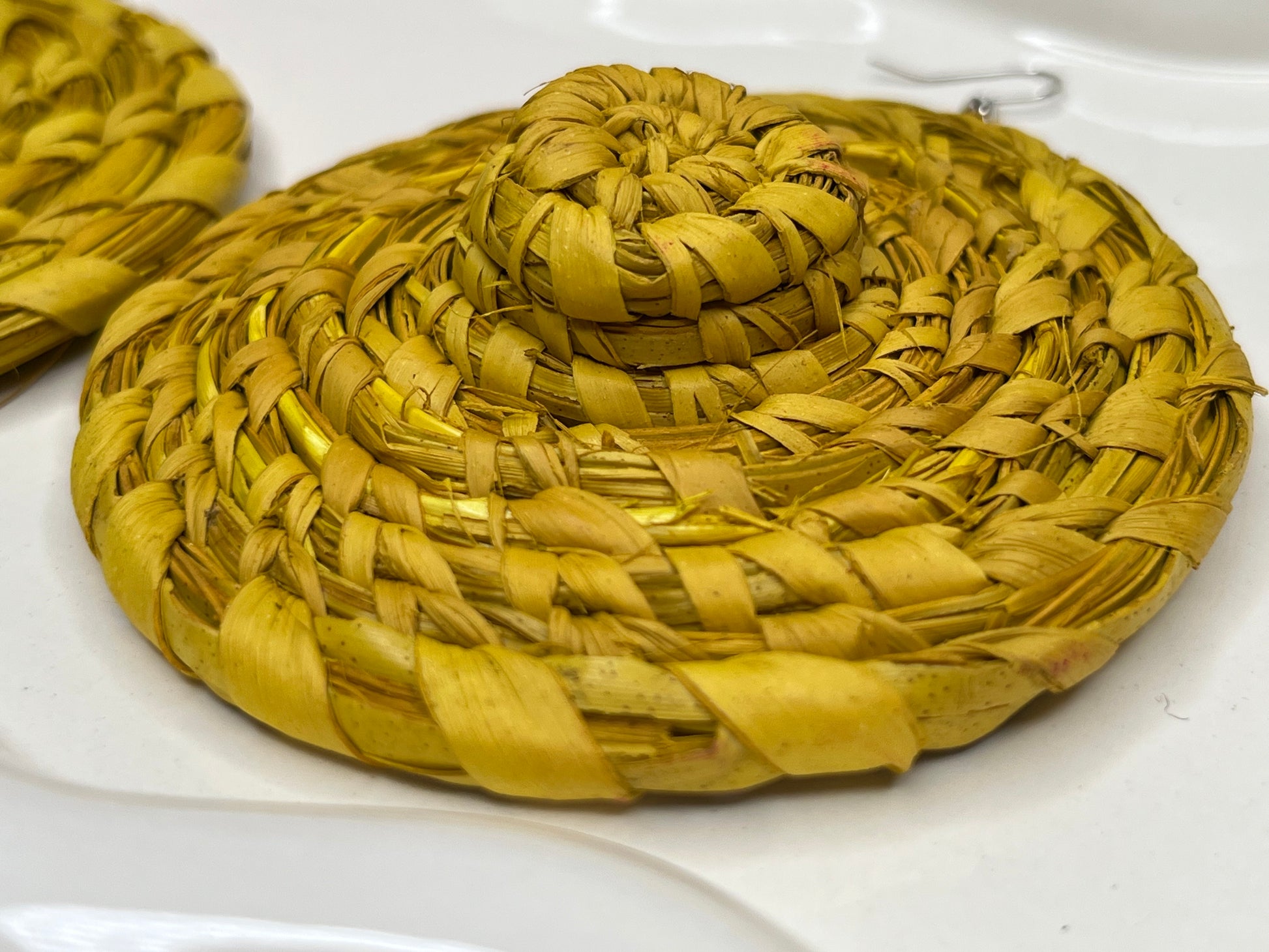 Yellow woven earrings  on a white surface